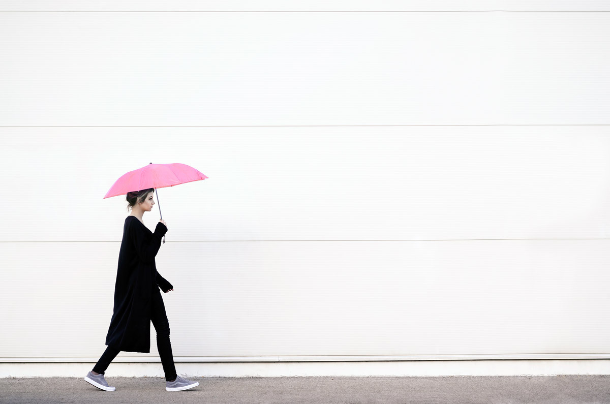 Ensam kvinna med rosa paraply