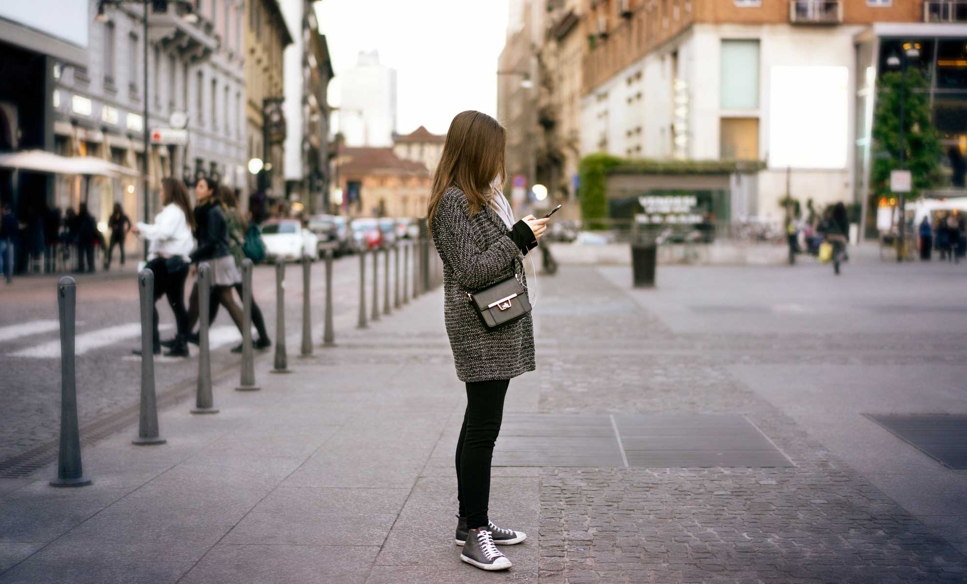 Girl standing on the street with an iphone