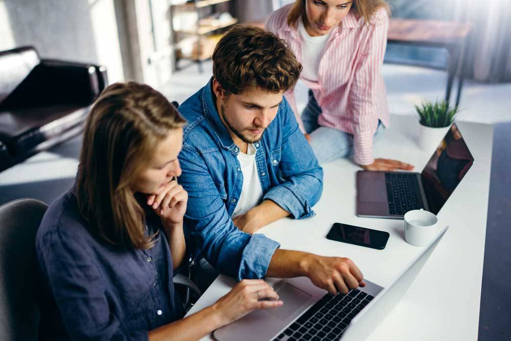Two marketeers by laptop in office